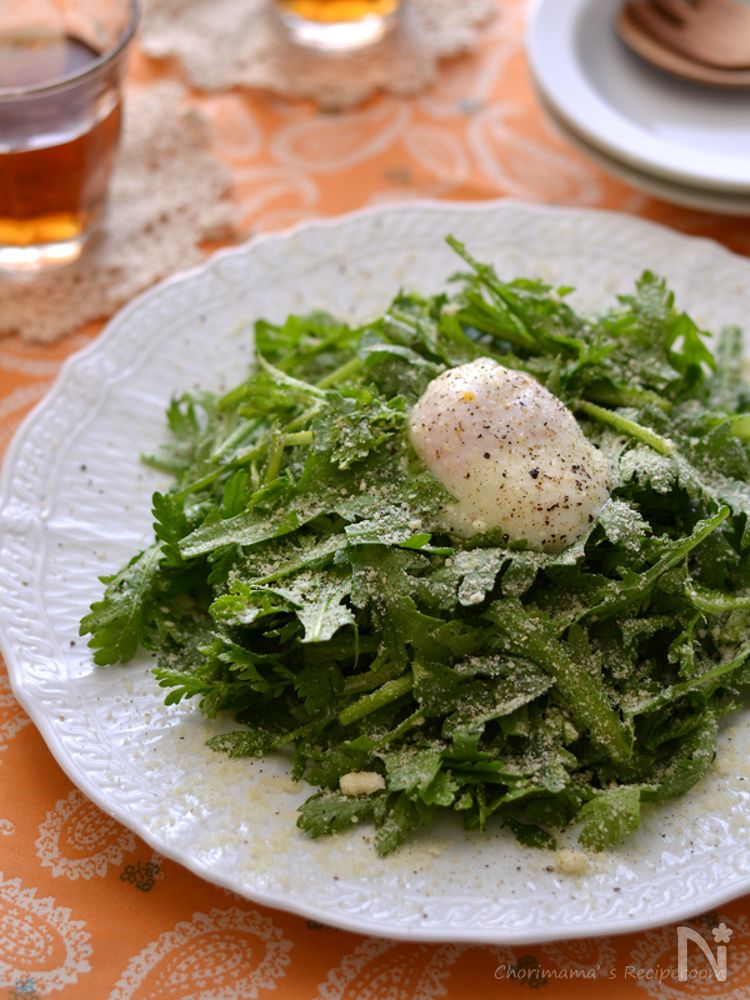 白色の丸皿に盛られた春菊のシーザーサラダ・温玉のせ