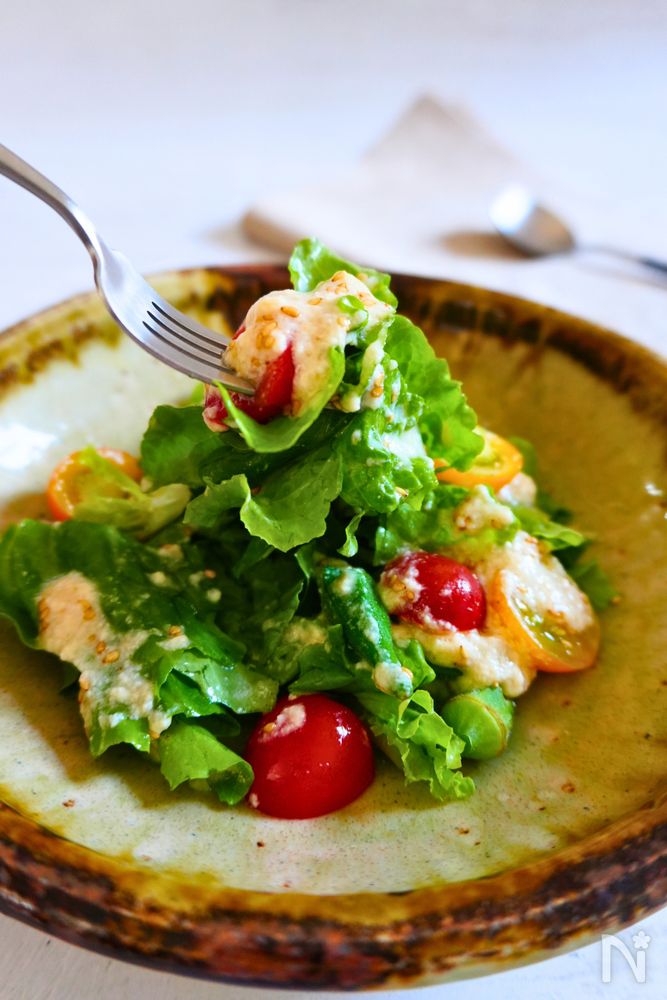 茶色の皿に盛られたレタスの豆腐ごまドレッシングサラダ