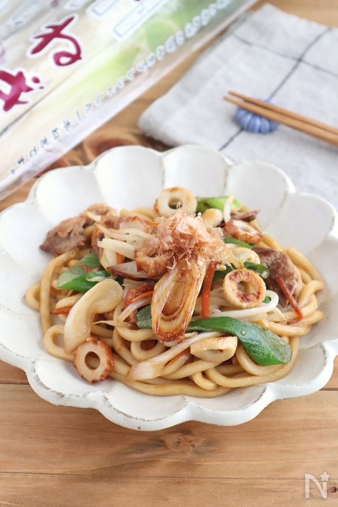 白い皿に盛りつけられたちくわとねぎの焼きうどん