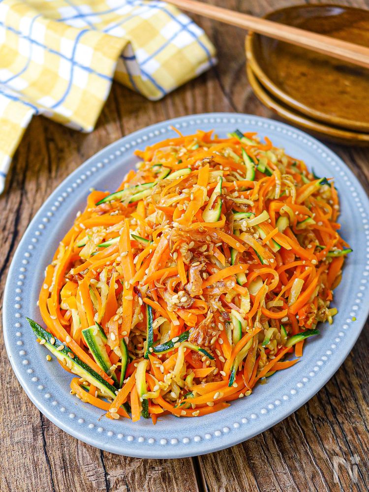青い皿に盛られたにんじんとズッキーニのおかかしりしり