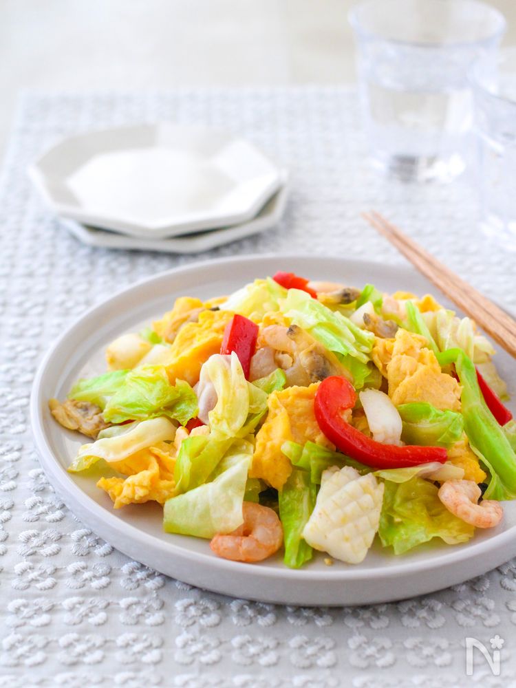 キャベツと卵の海鮮炒めを盛った大皿がある食卓
