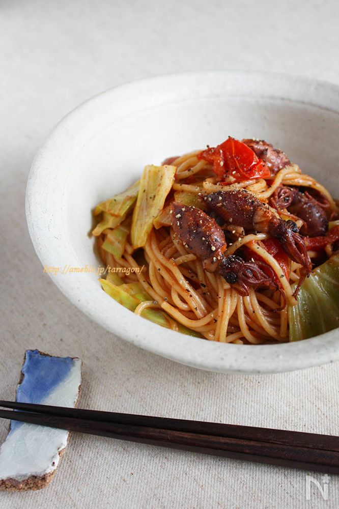 白い器に盛り付けられたほたるいかと春キャベツとトマトのパスタ