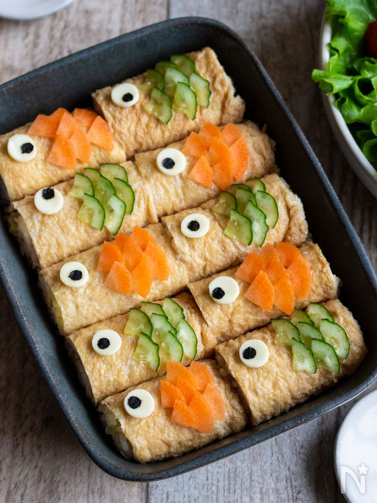 黒い器に並べた、こいのぼり形のいなり寿司