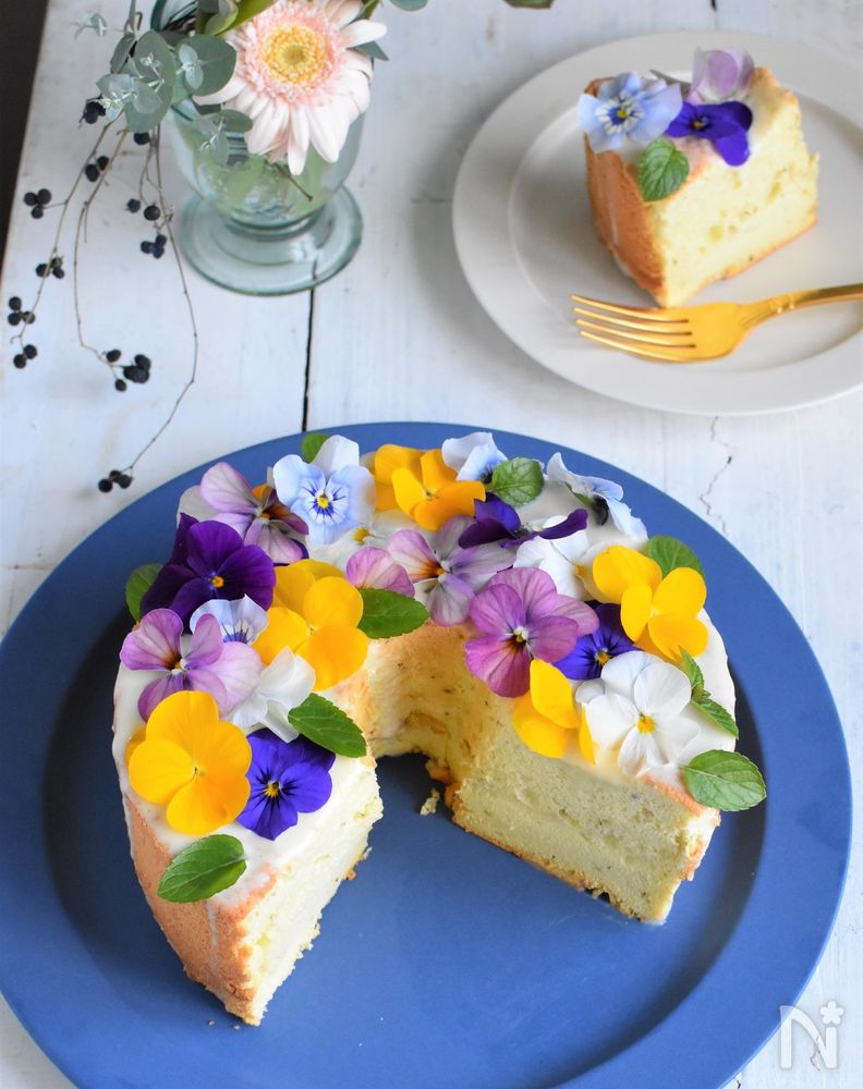 青い皿にのせたエディブルフラワーのミントシフォンケーキ