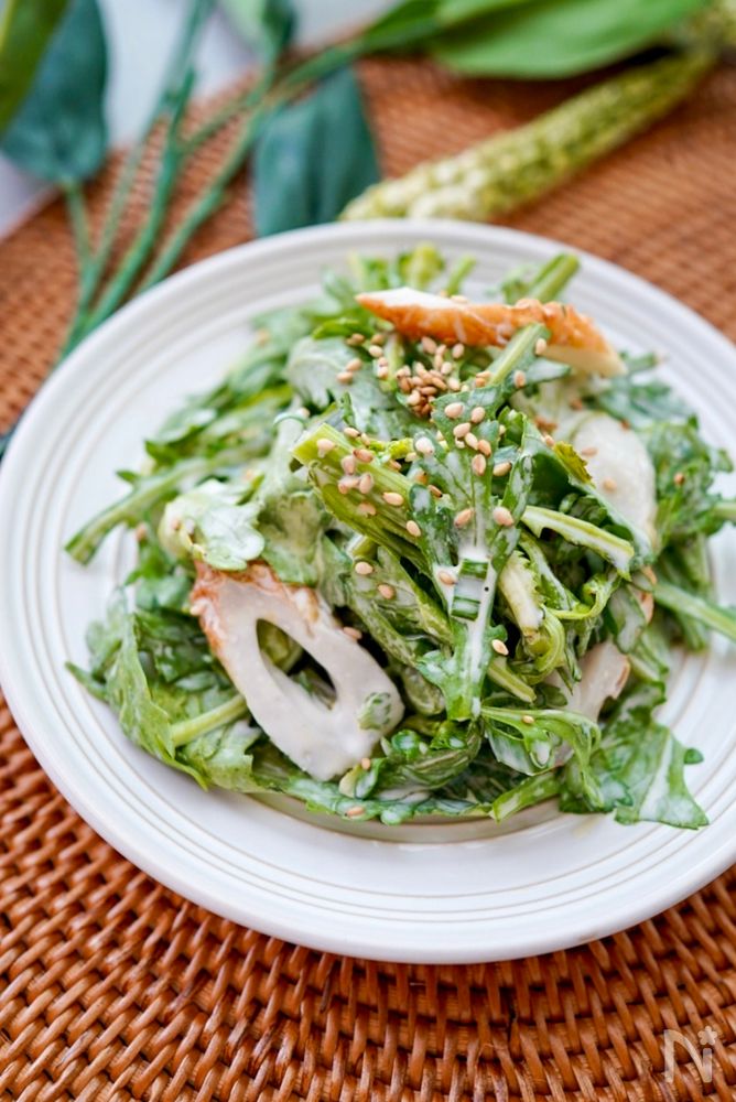 白色の丸皿に盛られた春菊とちくわのからしマヨ和えサラダ