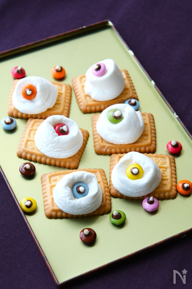 緑色の皿に盛り付けられたカラフル目玉のマシュマロクッキー