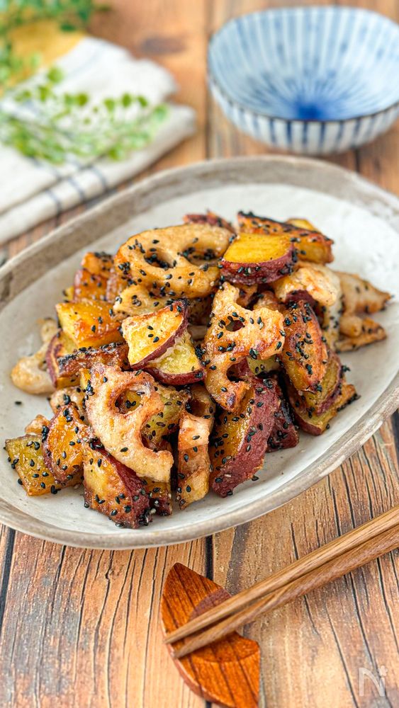 楕円形の皿に盛り付けたさつまいもとれんこんの甘辛炒め