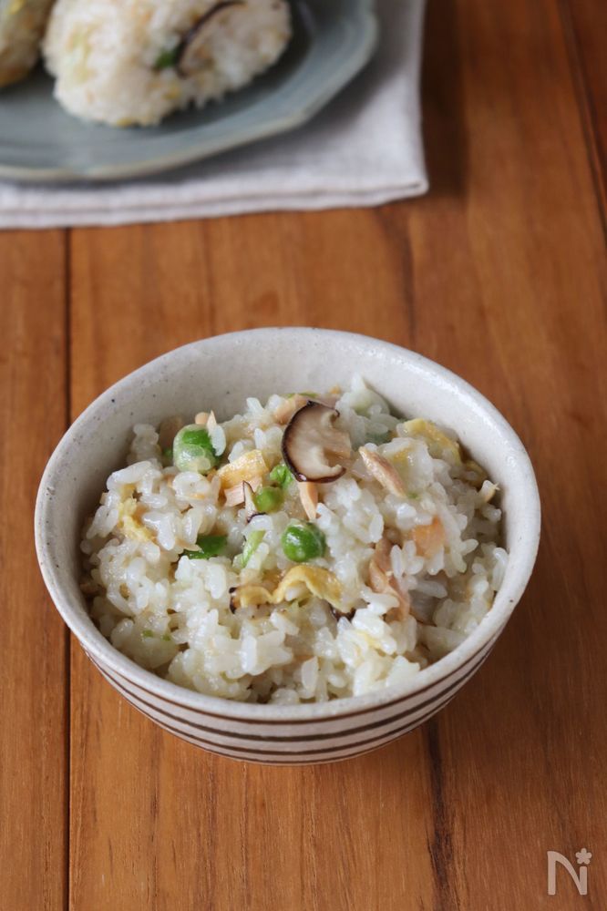 柄物の茶碗に盛られたえんどう豆とツナのおこわ