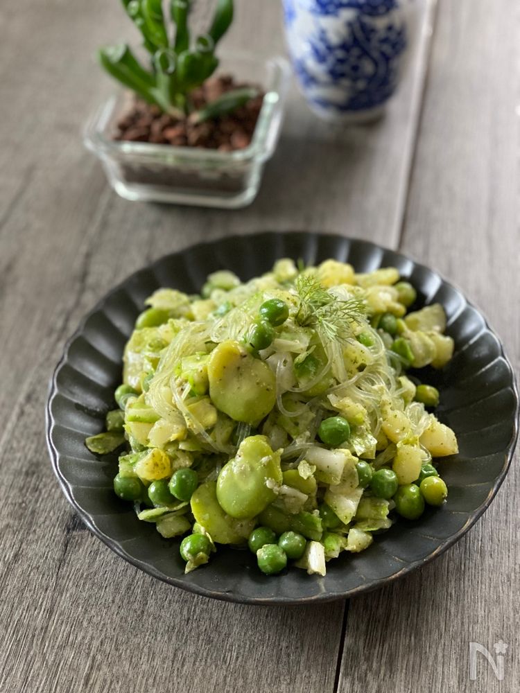 黒い皿に盛りつけられたえんどう豆の春雨サラダ