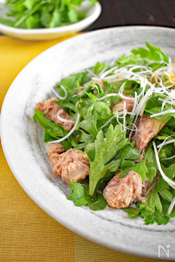 白色の丸皿に盛られたさば缶と春菊のサラダ