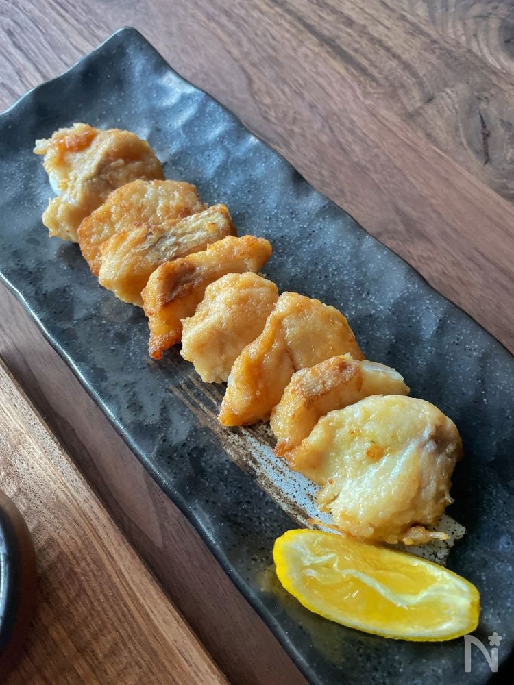 黒い皿に盛り付けられたたらの竜田揚げ