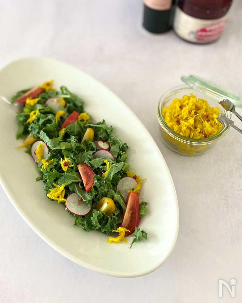 楕円の白色の皿に盛られた食用菊のピンクペッパーマリネ