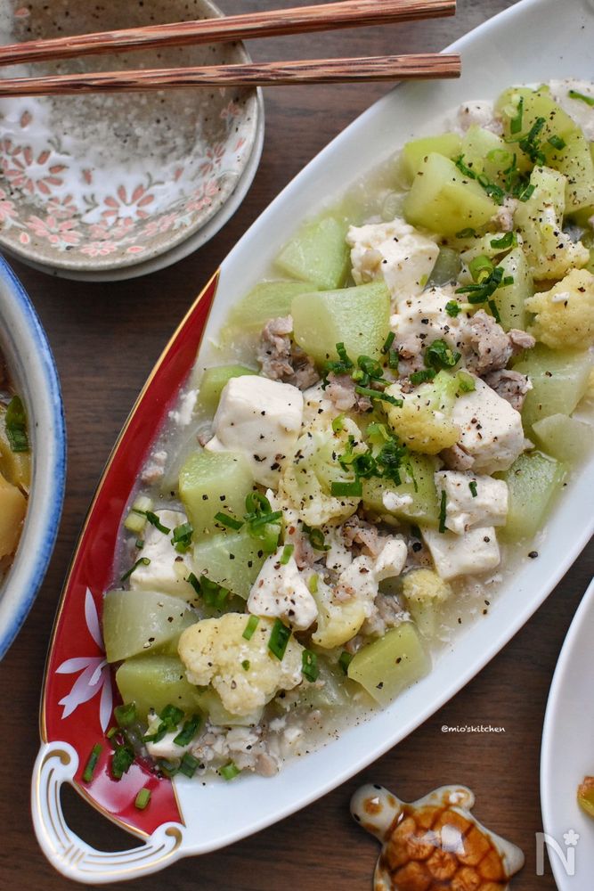 赤色と白色の皿に盛られたハヤトウリと豆腐、豚バラの中華あん