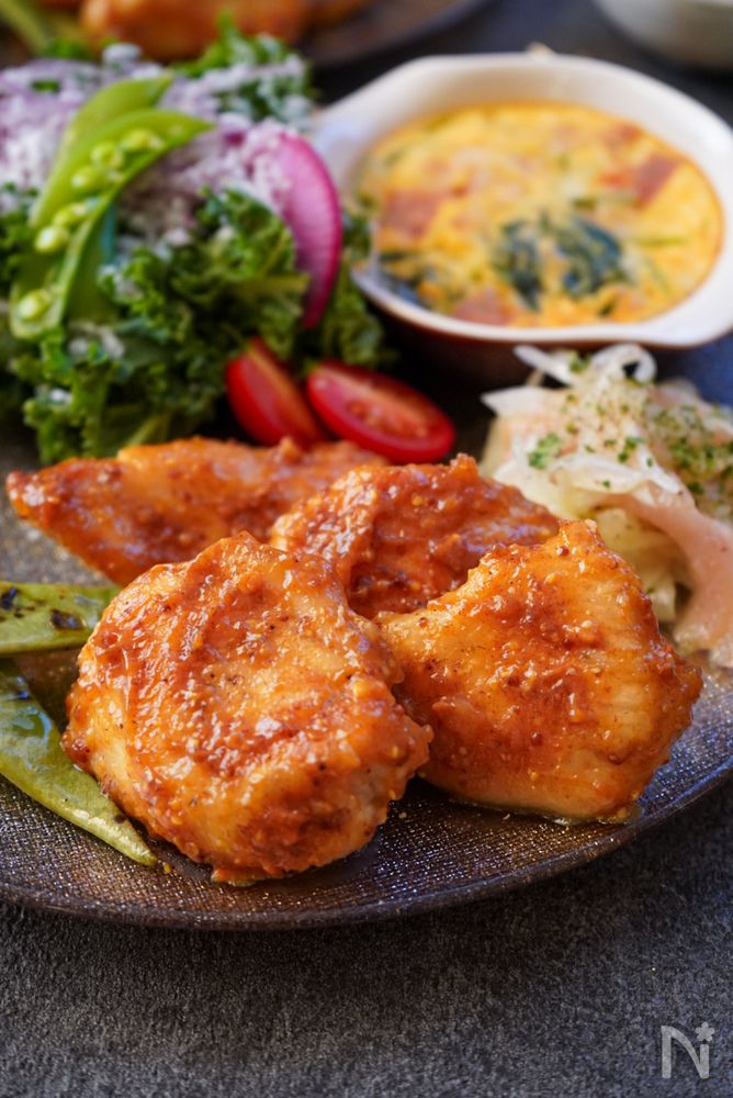 黒色の皿に盛られた完熟柿のマスタードチキン