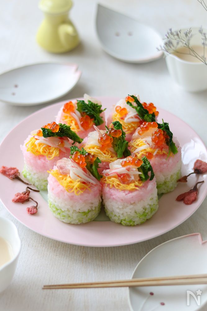 ピンク色の丸皿に盛られたひな祭りの3色押し寿司