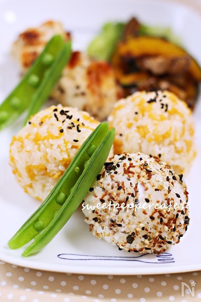 丸いおにぎり3つとさやえんどうなどが置かれている