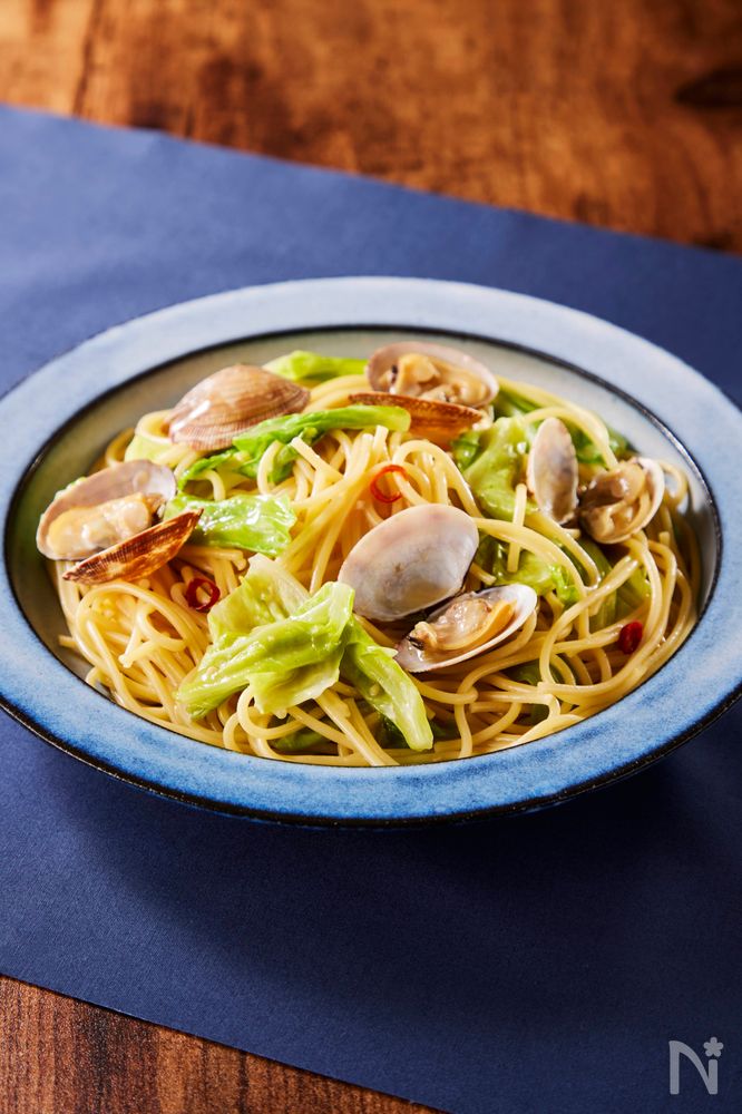 青い皿に盛り付けられた春キャベツとあさりのスープパスタ