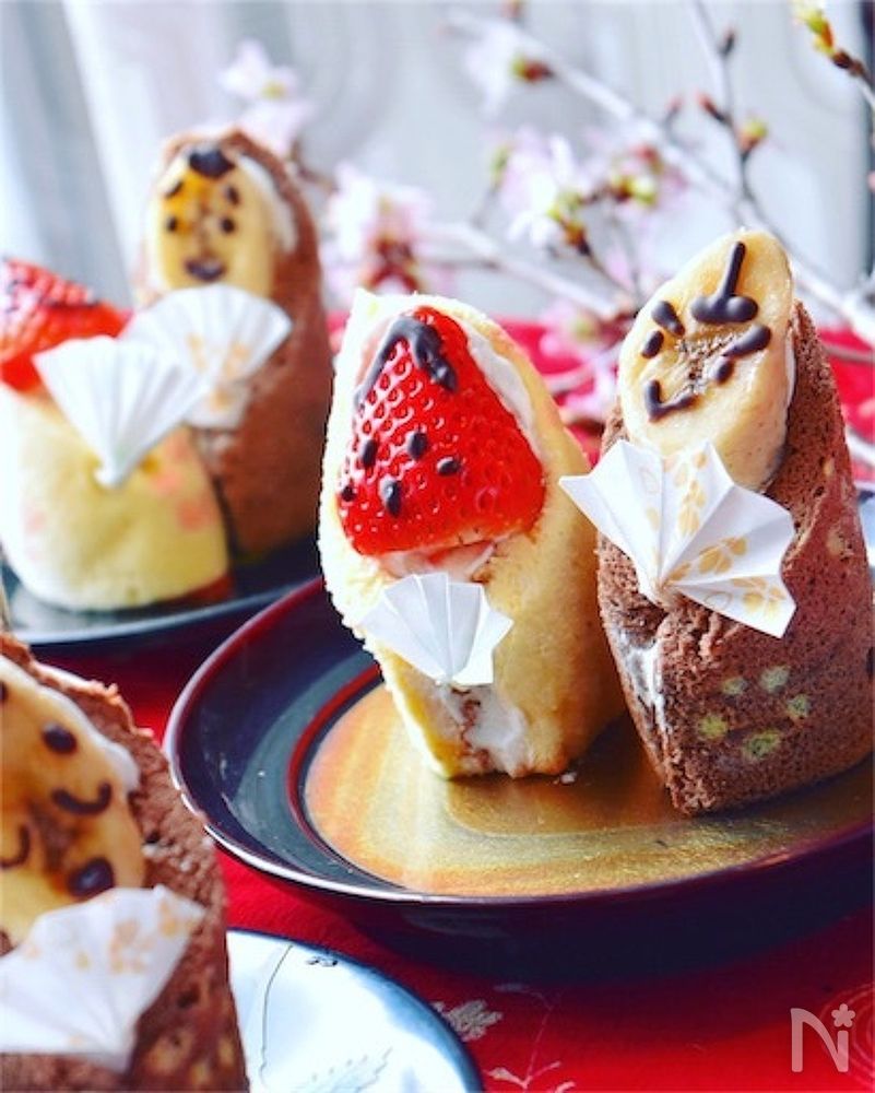 和風の皿に盛りつけた苺お雛様とバナナお内裏様のロールケーキ