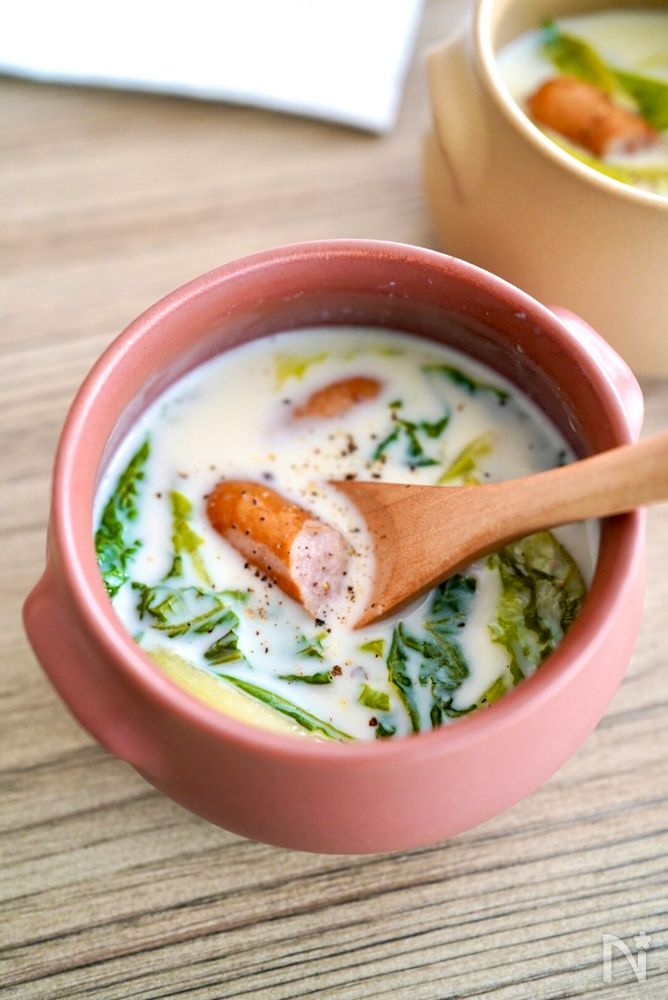 赤いスープカップに入ったレタスとウインナーのミルクスープ