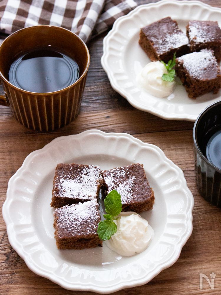 白い皿に、豆腐ブラウニーとホイップクリームを盛り付けた様子