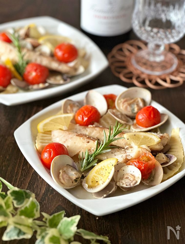 タラとはまぐりとたけのこのレモン風アクアパッツァが皿に盛り付けられているところ