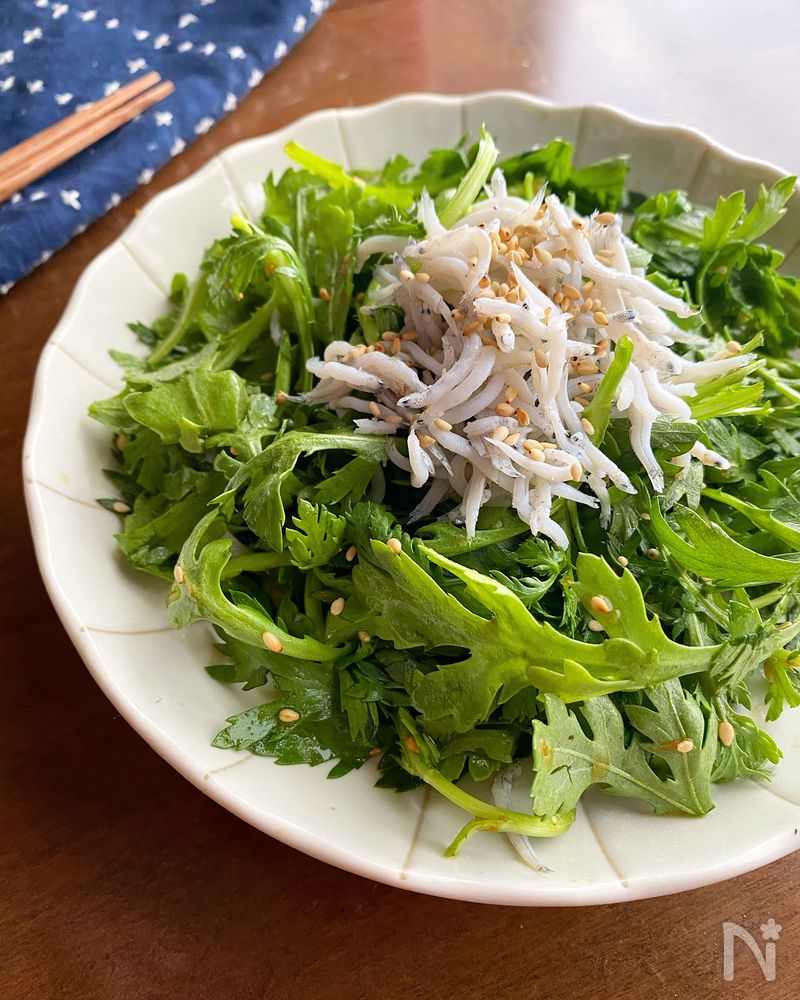 白色の皿に盛られた春菊としらすの柚子胡椒ポン酢サラダ