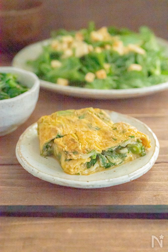 白い丸皿に盛り付けた春菊のチーズ卵焼き