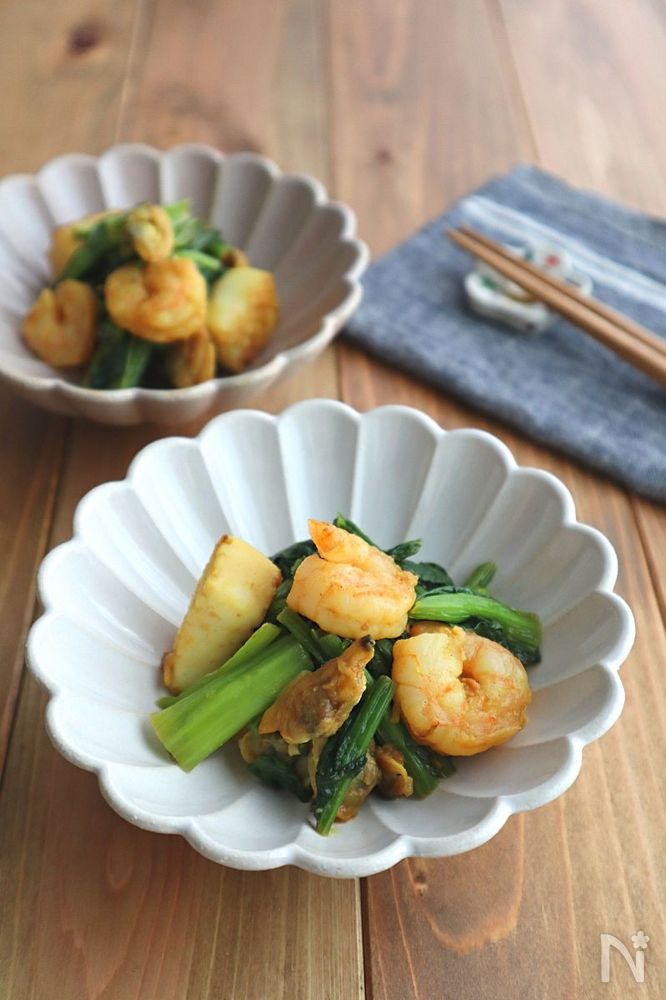 シーフードミックスと小松菜のカレー炒めが皿に盛り付けられているところ