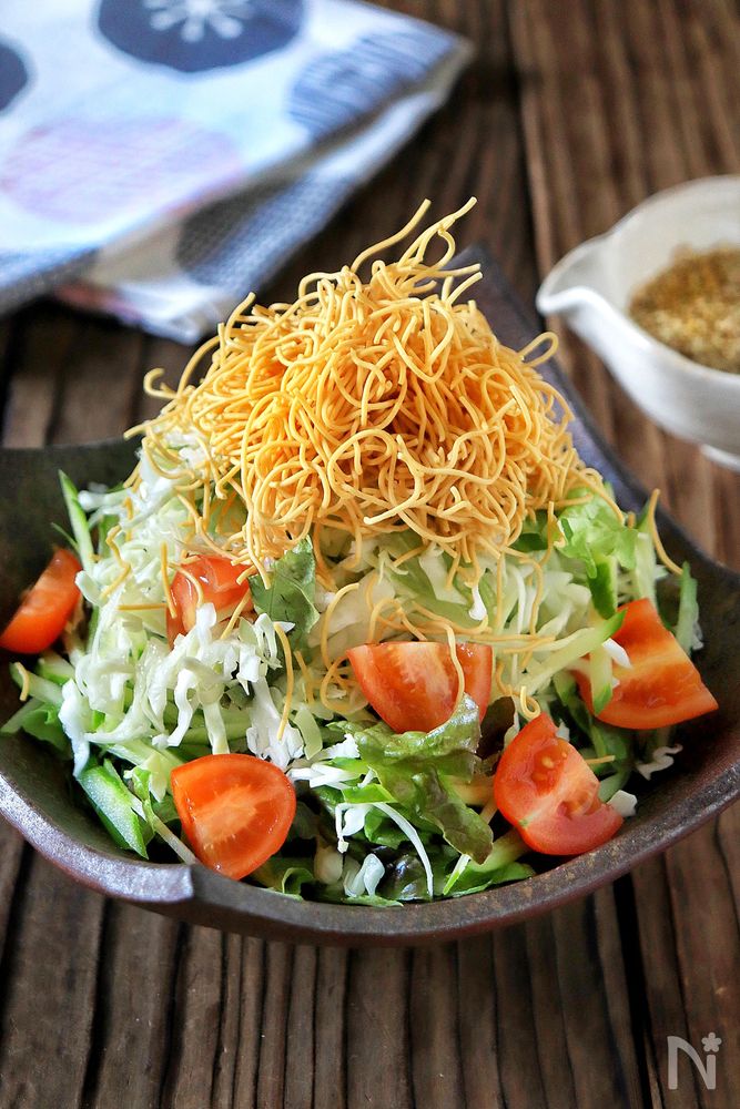 居酒屋風のぱりぱりサラダが黒い皿に盛り付けられているところ